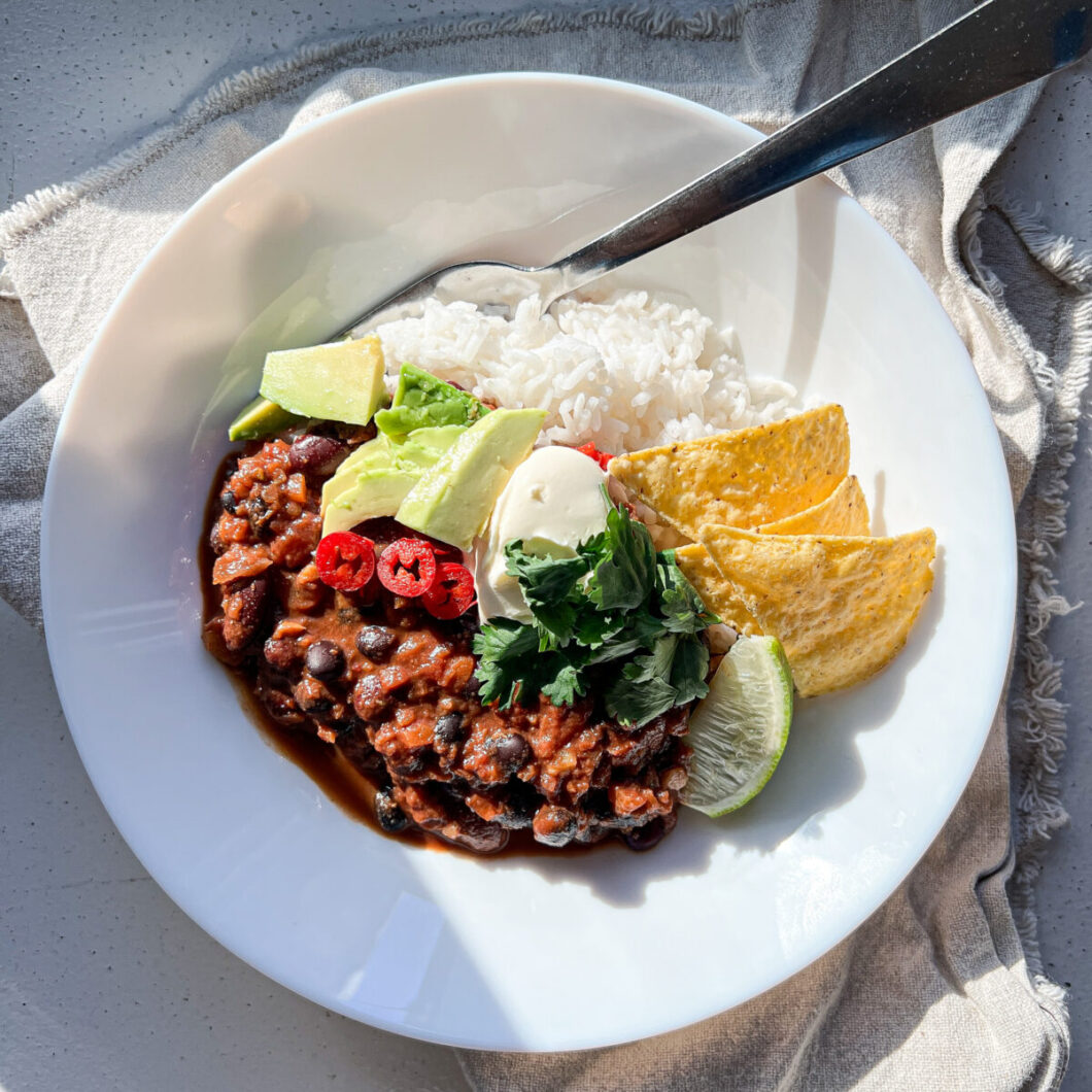chili sin carne serveret med ris, tortillachips og avocado